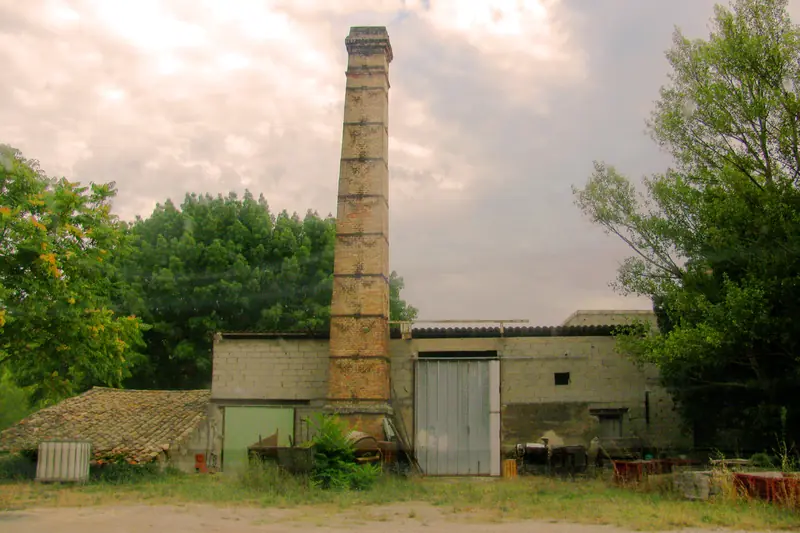 Ancienne distillerie de lavande en Provence, haute cheminée de briques et bâtiments bas