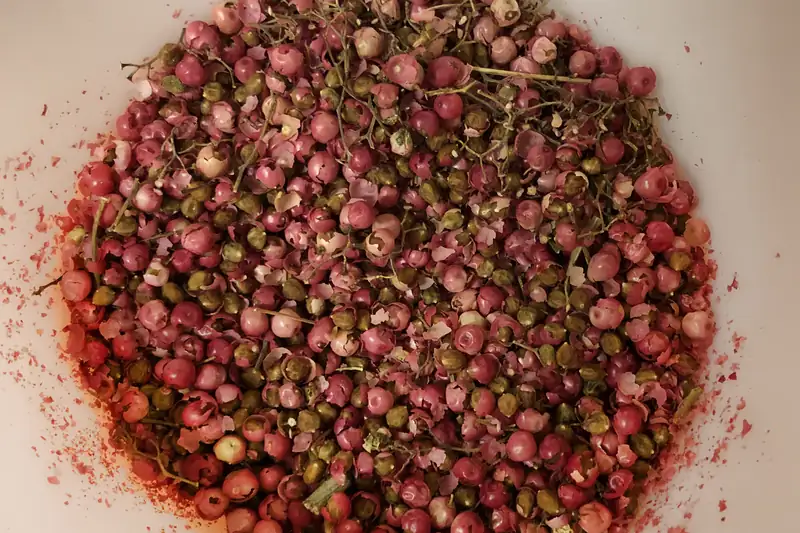 Baies roses séchées à la peau cassante réunies en tas rond sur une assiette