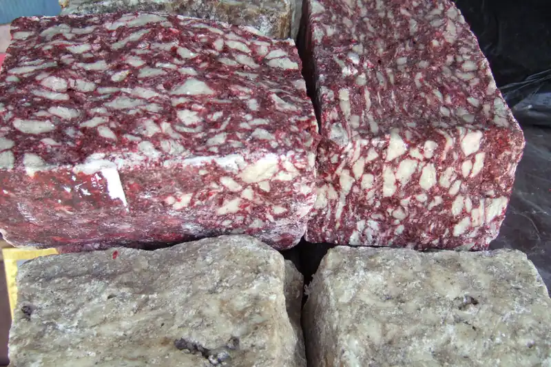 Blocs de résine de benjoin compressée, marbrés de rouge et de blanc, sur un marché