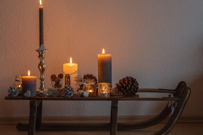 Candles and pine cones set on a small wooden sledge as a winter decoration