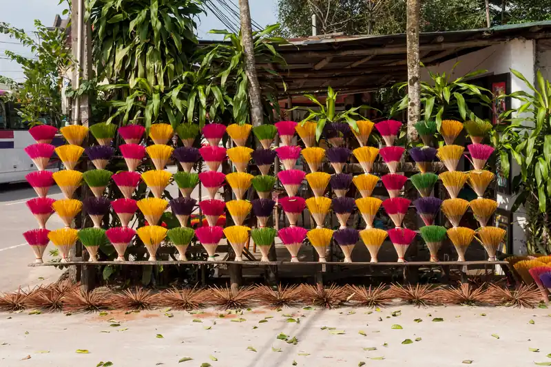 Bouquets de bâtons d'encens multicolores ouverts en éventail qui sèchent à Hué