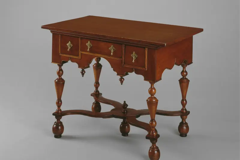 Antique American dressing table in dark wood with turned legs, on a grey background