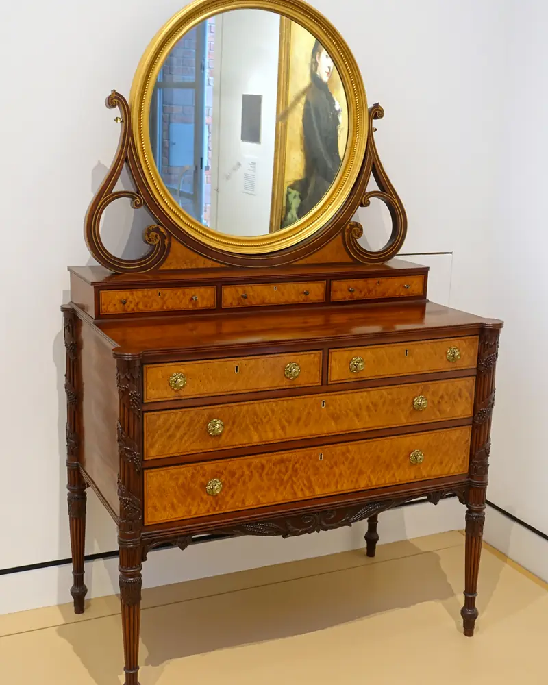 Commode à miroir de 1810 en acajou et érable moucheté exposée dans un musée