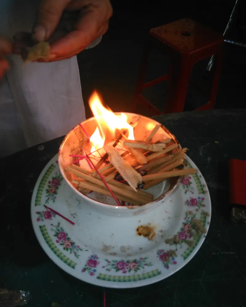 Copeaux de bois d'agar qui brûlent dans une tasse de porcelaine fleurie