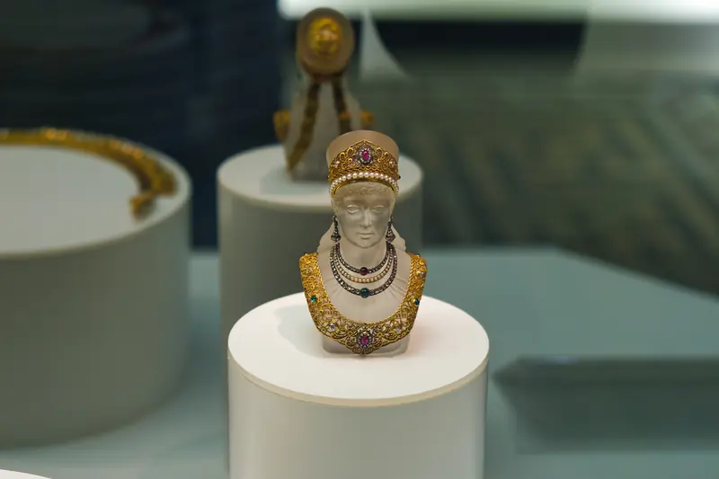 Antique perfume bottle shaped like a jewelled bust in a museum display case