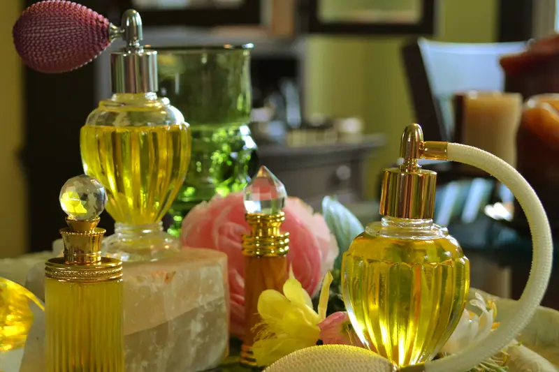 Glass perfume bottles with atomiser bulbs and golden juices on a flowery tray