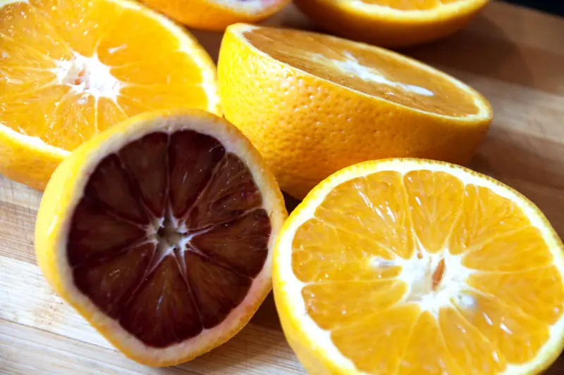 Oranges sanguines et oranges blondes coupées en deux, pulpe rouge à côté de pulpe dorée