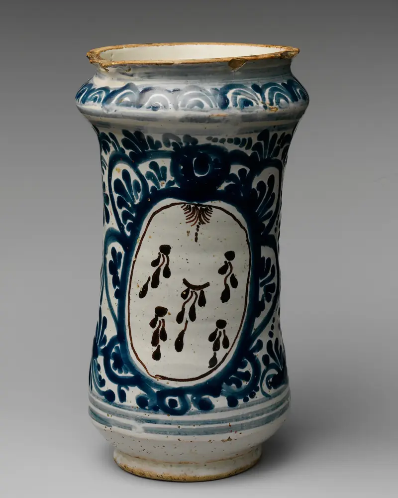 Mexican white earthenware apothecary jar with blue floral decoration, on grey