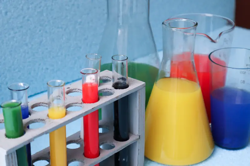 Tubes à essai et fioles de laboratoire remplis de liquides vert, jaune, rouge et bleu