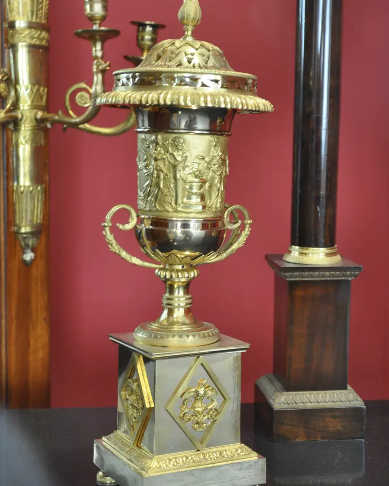 Nineteenth-century gilt bronze potpourri vase displayed against a red wall